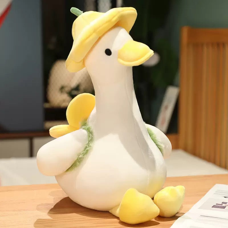 The duck plush toy, with a hat and a small flower on its back, feels as comfortable as a cloud, exuding a youthful spring-like atmosphere. It is a gift, a companion, and adds fun.