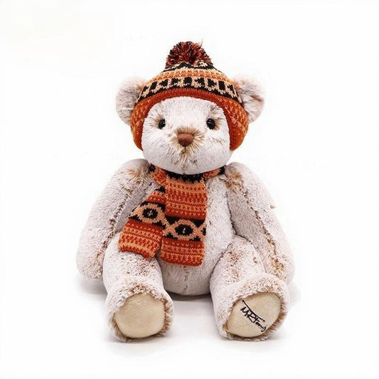 Cute British-style off-white short-haired teddy bear, wearing a knitted hat with pompom decoration and a knitted scarf in the same color