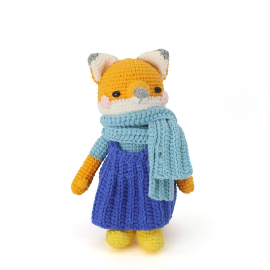 A handmade crocheted fox doll, featuring a light blue scarf paired with a dark blue skirt.It does not require glue, is made of pure cotton, feels soft, is safe and environmentally friendly, and is no problem for babies to bite.