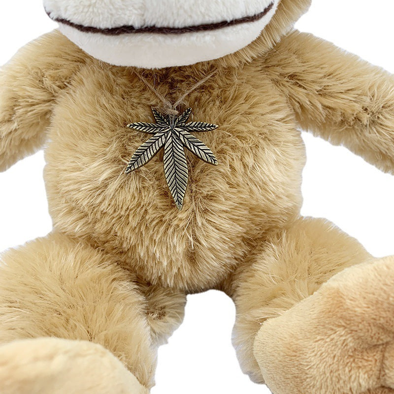 Adorable brown monkey plush toy, featuring a cute face, long limbs, and a leaf pendant on its chest, perfect as a kids' companion or decorative gift
