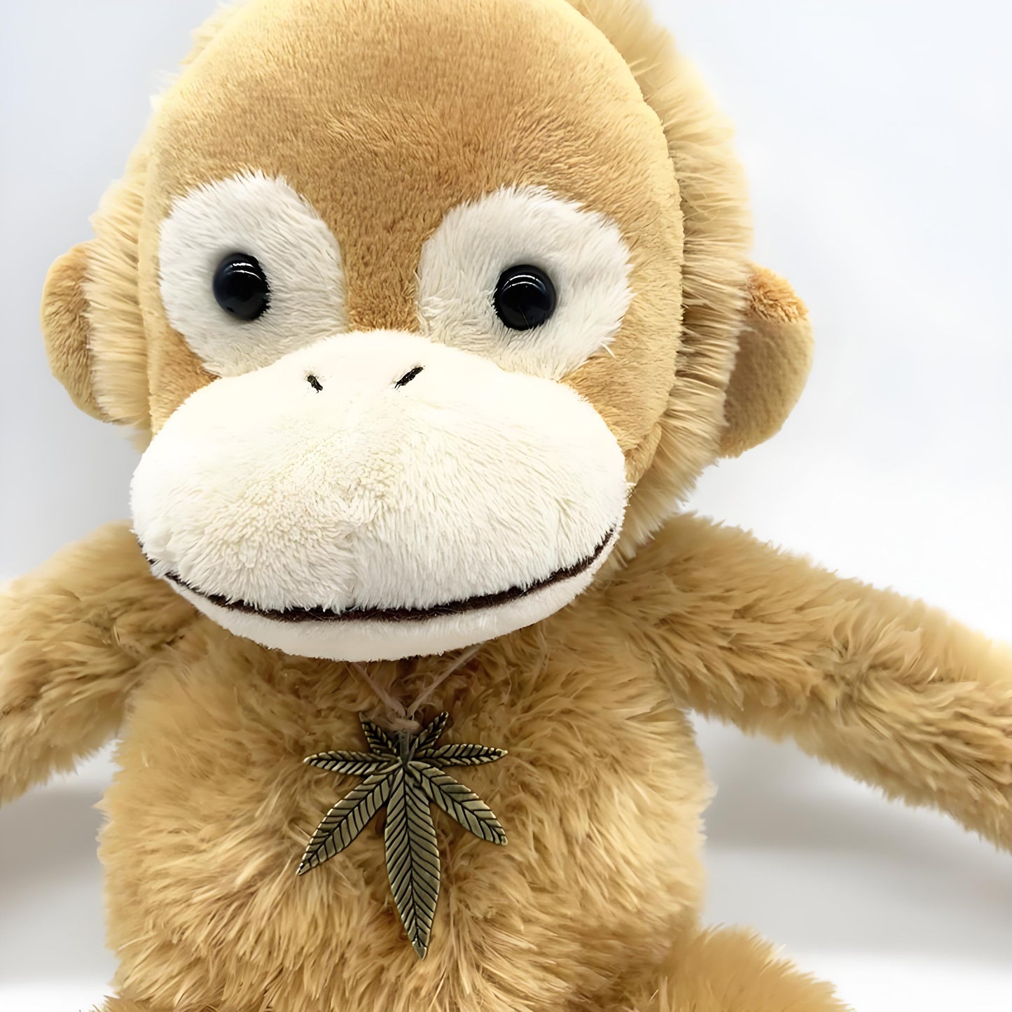 Adorable brown monkey plush toy, featuring a cute face, long limbs, and a leaf pendant on its chest, perfect as a kids' companion or decorative gift