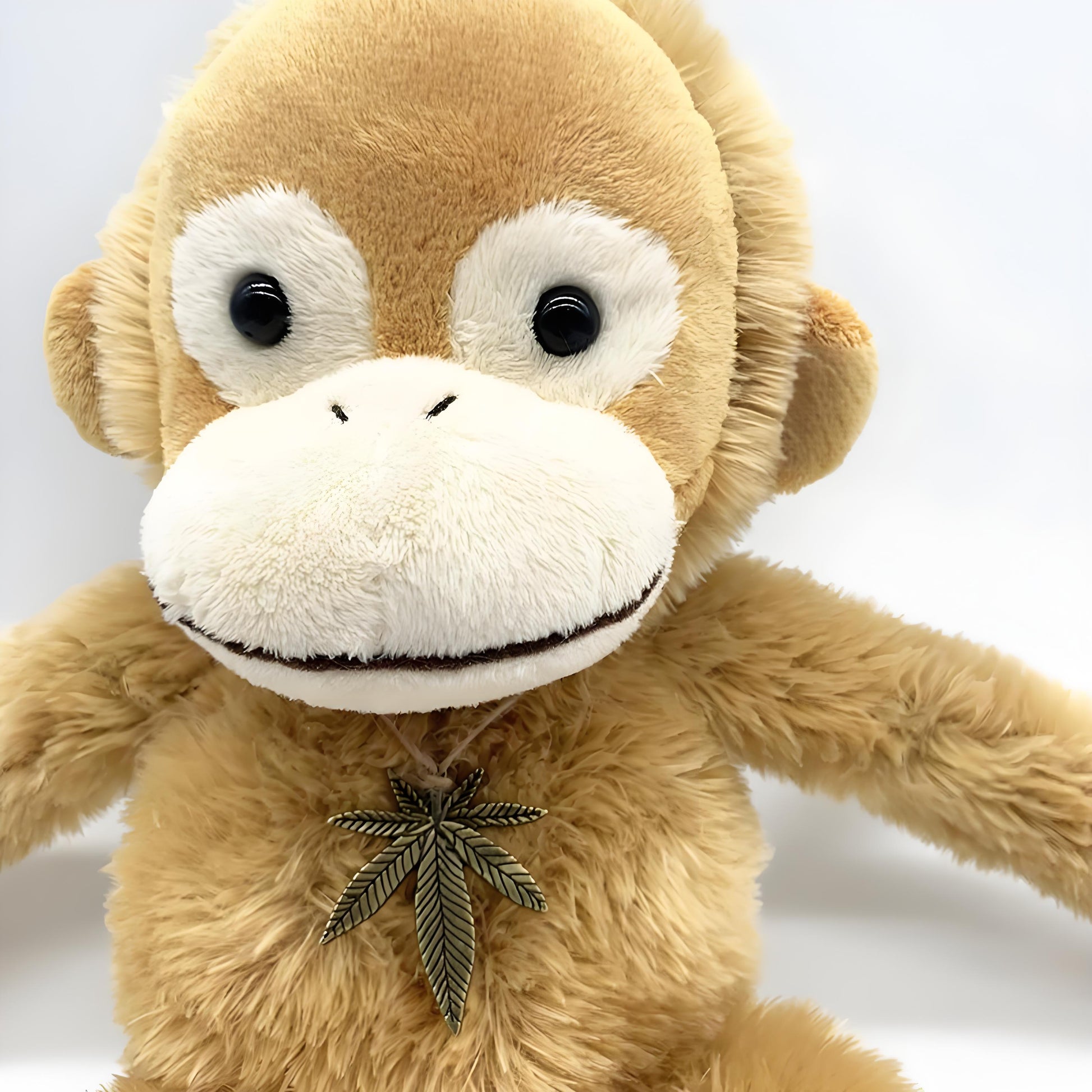 Adorable brown monkey plush toy, featuring a cute face, long limbs, and a leaf pendant on its chest, perfect as a kids' companion or decorative gift