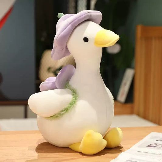 The duck plush toy, with a hat and a small flower on its back, feels as comfortable as a cloud, exuding a youthful spring-like atmosphere. It is a gift, a companion, and adds fun.